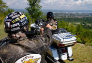 2 motorcycle riders sitting on their bikes, overlooking a scenic view 